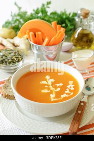 Cremesuppe im Herbst. Kürbissuppenpüree aus den Zutaten einer Kürbis-Karotte Kartoffel Ingwer Zwiebeln Knoblauchgewürze. Nahaufnahme. Stockfoto