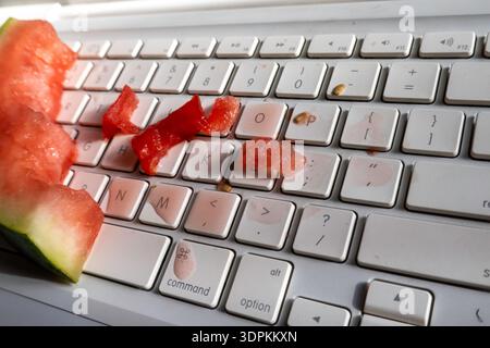 Nahaufnahme einer Wassermelone, die auf einer Computertastatur verschüttet wurde, 2026, USA Stockfoto
