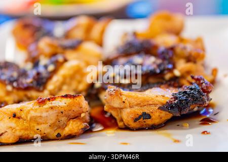 Saftige gegrillte Hähnchenstücke glasiert mit herzhafter Sauce und Sesamsamen Stockfoto