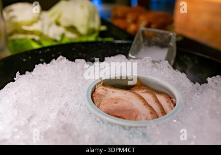 Knuspriges Eisbett mit frischen Schweinefleischscheiben, bereit für heiße Speisen. Stockfoto