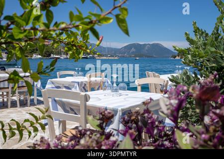 Serviert Tische in einer griechischen Taverne im Vathy Harbor, Meganisi Insel, Ionischen Meer, Griechenland während der Sommersaison. Horizontal. Stockfoto