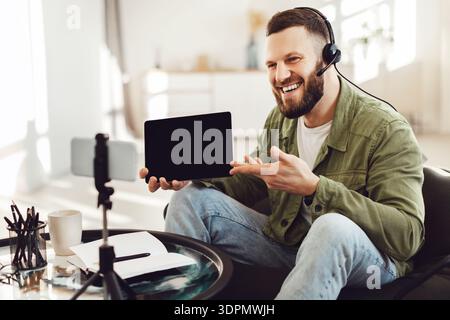 Mann Zeigt Dem Smartphone Den Tablet-Bildschirm Und Macht Zu Hause Videos Stockfoto