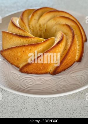 Hausgemachter Zitronenbundt-Kuchen auf weißem Teller Stockfoto