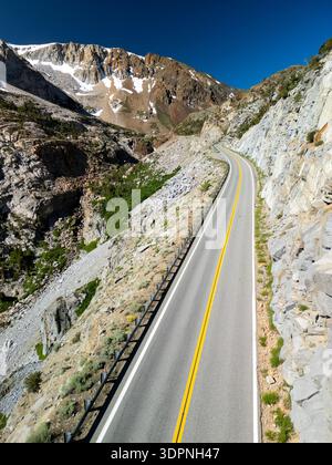 Luftaufnahme einer leeren Autobahn 120 in der dramatischen Landschaft der östlichen Sierras unter blauem Himmel ohne Verkehr Stockfoto