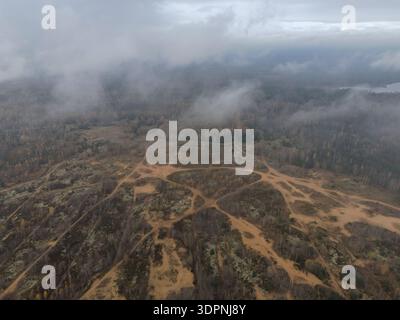 Aus der Vogelperspektive des Trainingsplatzes Dretunsky in Belarus zeigt sandiges Gelände mit durchquerenden Feldwegen, Bermshügeln, unebenem Wald und gedämpftem Autom Stockfoto