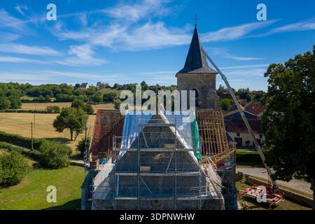 Eglise Saint Martin, Frankreich - 23. Juli 2020: Das Dach der Kirche Eglise Saint Martin ist von oben mit Gerüsten, Planen, freiliegenden Holzbalken und Baugeräten während der Renovierungsarbeiten in einem ländlichen Gebiet zu sehen. Stockfoto