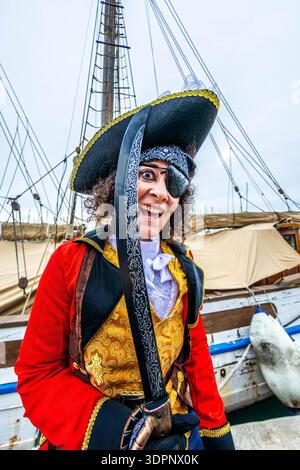 Fröhlicher Pirat mit Schwert und Augenklappe, der Karneval auf dem Schiffsdeck feiert Stockfoto