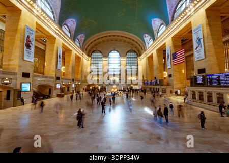 Großer Innenblick auf die Haupthalle des Grand Central Terminals in Manhattan, New York City. Bewegungsunschärfe von Pendlern, die unter dem legendären himmlischen C laufen Stockfoto