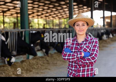 Latino-amerikanische Bäuerin, die auf dem Kuhhof steht Stockfoto