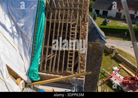 Eglise Saint Martin, Frankreich - 23. Juli 2020: Die Dachkonstruktion der Kirche Eglise Saint Martin ist von oben mit freiliegenden Holzbalken, Gerüsten, Planen und Baugeräten während der Renovierungsarbeiten zu sehen. Stockfoto