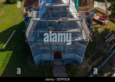 Eglise Saint Martin, Frankreich - 23. Juli 2020: Die Fassade der Kirche Eglise Saint Martin ist von oben mit umfangreichen Gerüsten, Baumaterialien und Ausrüstungen zu sehen, die während der Renovierungsarbeiten in einem ländlichen Gebiet vorhanden sind. Stockfoto