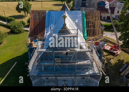 Eglise Saint Martin, Frankreich - 23. Juli 2020: Das Dach der Kirche Eglise Saint Martin ist von oben mit Gerüsten, Planen, freiliegenden Holzbalken und Baugeräten während der Renovierungsarbeiten in einem ländlichen Gebiet zu sehen. Stockfoto