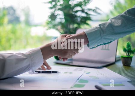 Im Büro fand ein Geschäftstreffen statt, bei dem ein Mann und eine Frau zusammen mit ihrem Team über Finanz- und strategische Konzepte diskutierten Stockfoto