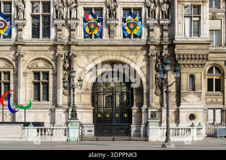 Paris, Frankreich - 20. April 2022: Die Skulptur des paralympischen Symbols ist vor der reich verzierten Steinfassade des Hotels de Ville mit dekorativen Fahnen, Statuen und schmiedeeisernen Toren zu sehen. Stockfoto