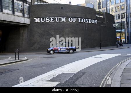 London, Großbritannien. 31. Januar 2025. Ein klassisches schwarzes Londoner Taxi am Museum of London vorbei, das die Geschichte der Stadt von der prähistorischen bis zur modernen Geschichte abdeckt Stockfoto