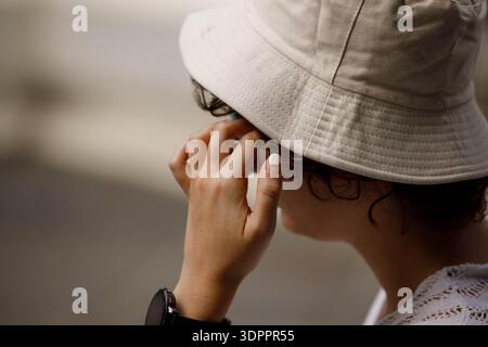 Frau in einem cremefarbenen, weiträumigen Stoffhut, Walking und Sightseeing, Hand- und Nagelhaut, Nahaufnahme Stockfoto