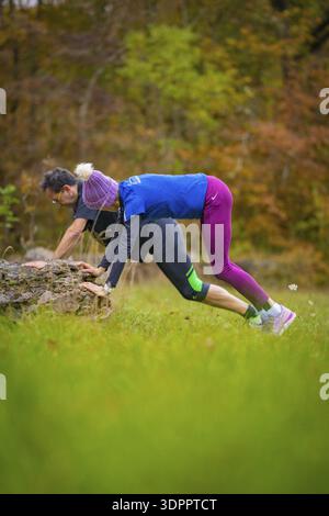 Sportliches Paar mit Übungen auf Felsen in herbstlicher Natur, Mittelstreckenläuferin Katharina Jaiser, Gechingen, Deutschland Stockfoto