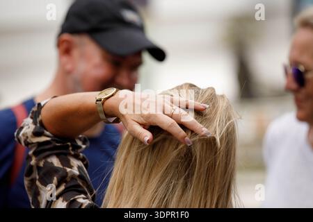 BANGKOK, THAILAND-21. JAN 2026: Frau, die ihr lockiges Haar, die Haut und die Haarstruktur der Hand berührt, Nahaufnahme Stockfoto