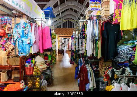 CAN Tho, Vietnam - 19. Januar 2020: Auf dem Nachtmarkt werden Stände mit Kleidung, Hüten, Handtaschen und Souvenirs gesehen. Kleidung und Accessoires werden auf Regalen und Regalen unter künstlicher Beleuchtung ausgestellt. Stockfoto