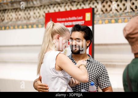 BANGKOK, THAILAND-21. JAN 2026: Ein Touristenpaar steht zusammen, trinkt Wasser aus einer Plastikflasche, weibliche Haut, Seitenprofil, im Wat Arun. Stockfoto
