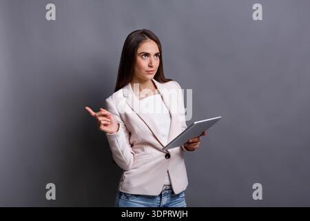 Geschäftsfrau, die eine Präsentation hält, während sie das Tablet in der Studio-Umgebung hält Stockfoto