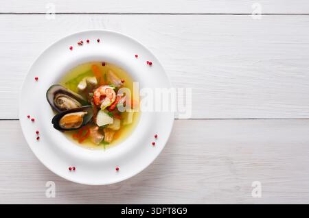 Köstliche Meeresfrüchte-Suppe mit verschiedenen Muscheln und Gemüse auf einer weißen Platte Stockfoto