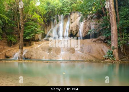 Der Sai Yok Noi Wasserfall fließt über glatte Felsformationen in einen ruhigen, flachen Pool, der von dichtem Wald umgeben ist. Stockfoto