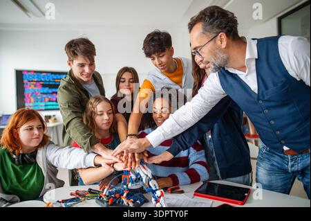 Eine Gruppe von Schülern feiert ein erfolgreiches Experiment mit Roboterhand. Stockfoto