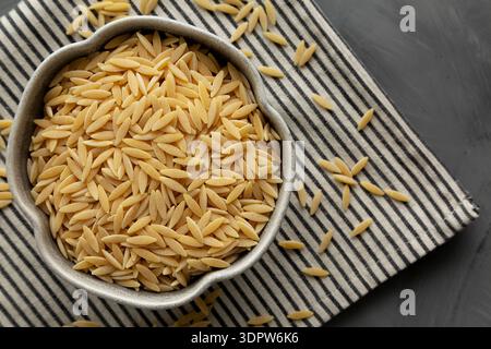 Rohe Bio-Orzo-Pasta in einer Schüssel, Draufsicht. Stockfoto