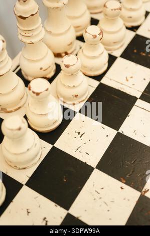 Nahaufnahme von alten Schachfiguren auf kariertem Brett Stockfoto