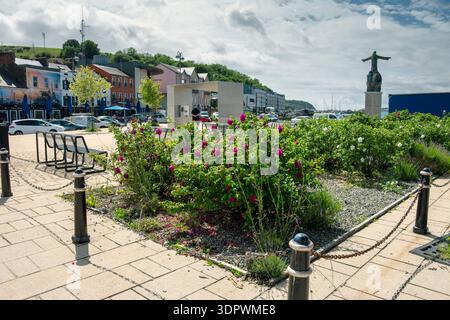 Blumenausstellung im Wolfe Tone Square, Bantry, County Cork, Irland. Statue von St. Brendan dem Navigator, von Imogen Stuart, rechts. Stockfoto