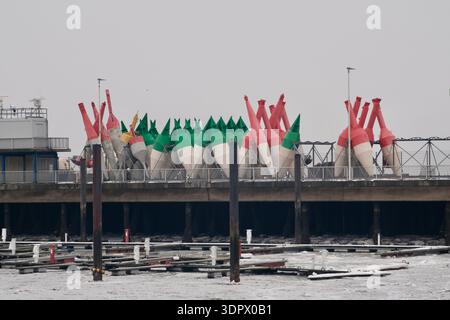 Große bunte Navigationsojen, die bei Ebbe in einem Industriehafen auf einer Hafenplattform gelagert werden. Stockfoto