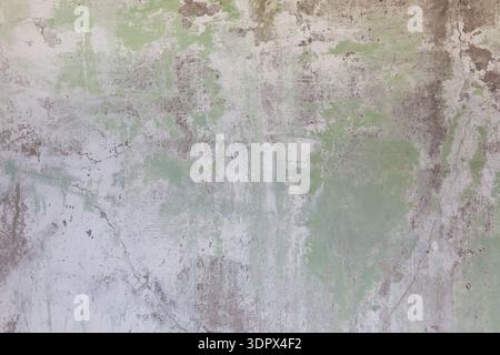 Alte Wand mit verblasster Farbe, die Anzeichen von Verschleiß und Alter in einer einfachen Umgebung zeigt Stockfoto