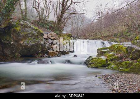 Kleine Waldkaskade über Moosfelsen in Giresun. Wunderschöne lange Sicht eines kleinen Wasserfalls, der durch ein felsiges Flussbett mit lebhaftem Grün stürzt Stockfoto