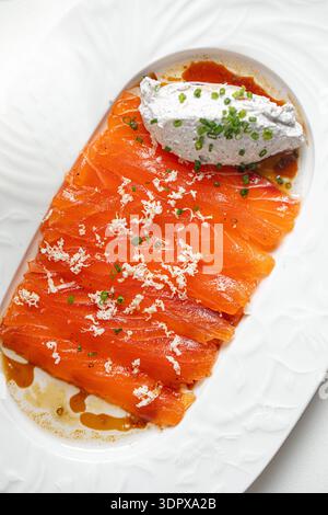 Lachsscheiben mit cremiger Sauce und Kräutern Stockfoto