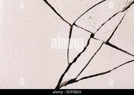 Die gerissene Oberfläche zeigt interessante Muster in einem trockenen Material an einem hellen Tag Stockfoto