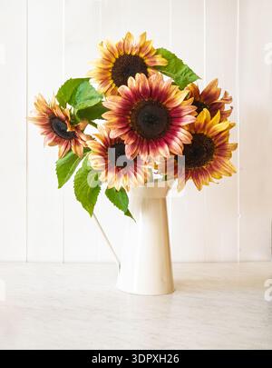 Ein Strauß rustikaler Sonnenblumen in einer Blechvase. Stockfoto