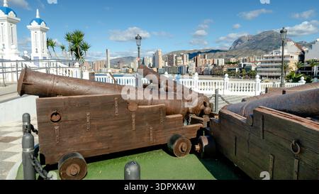 Historische Kanonen an der Plaza del Castillo in Benidorm, Alicante, mit Panoramablick auf die Skyline der Costa Blanca und die Berge. Der Tatort heiratet Historin Stockfoto