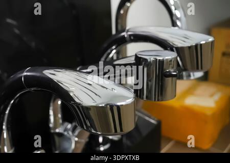 Gebrauchsfertige Wasserhähne und Wasserhähne am Ladentisch. Stockfoto