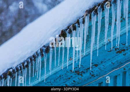 Eiszapfen auf dem Dach des Hauses. Sturzgefahr Stockfoto