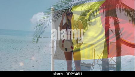 Stehende Frau in kariertem Hemd mit rotem Hut mit Sonnenschirmen am isle Beach, Überzug mit dreifarbiger Flagge Stockfoto