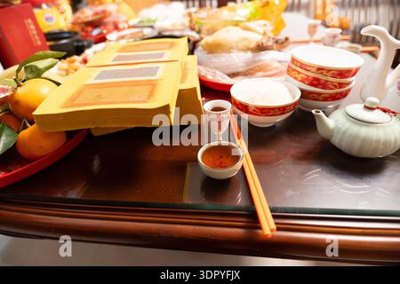 Chinesischer Neujahrsaltar mit Weihrauch, Tee, Orangen und zeremoniellen Opfern auf Holztisch Stockfoto