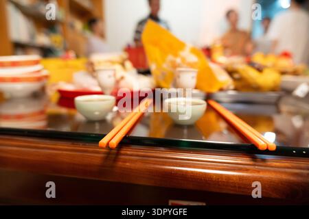 Chinesisches Restaurant, Tisch mit Essstäbchen, kleinen Schüsseln und Dim Sum im Hintergrund Stockfoto