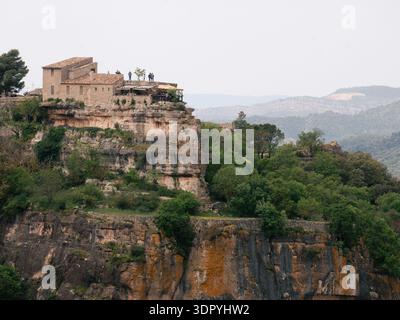 Siurana, Spanien - 01. Mai 2025: Steinbau am Klippenrand mit Blick auf das Tal mit Bäumen und Bergen Stockfoto