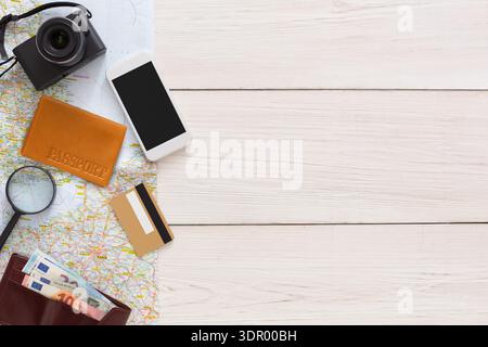 Reiseeinrichtung mit Kamera, Smartphone, Karten und Reisedokumenten auf dem Tisch Stockfoto