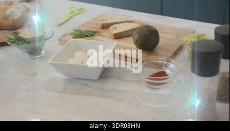 Die Zutaten des Frühstücks werden auf der Marmortheke in der Küche mit einer weißen Schüssel mit vier Eiern gezeigt Stockfoto