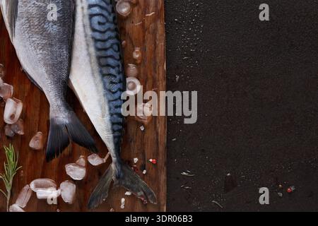 Frischer Fisch auf einem Schneidebrett mit Eis und Kräutern bereit für die Zubereitung Stockfoto