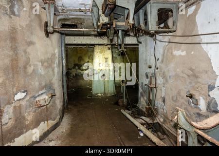Cartagena, Spanien - 1. September 23: Langer Korridor, der zu einer verrosteten Maschineneinheit in der verlassenen Küstenfestung Batería de Castillitos bei Cartagen führt Stockfoto