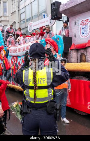 Rosenmontagszug in Düsseldorf, Einsatzkräfte, sichern, begleiten den Umzug, Polizistin mit geschenkten Blumen Sträußchen, Strüsschen, bei teils starkem Regen, NRW, Deutschland Rosenmontag DUS *** Rosenmontag Parade in Düsseldorf, Rettungsdienste, sicher, begleiten die Parade, Polizistin mit Blumensträußen, Sträußchen, bei teils starkem Regen, NRW, Deutschland Rosenmontag DUS Stockfoto