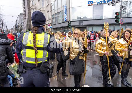 Rosenmontagszug in Düsseldorf, Einsatzkräfte, sichern, begleiten den Umzug, Polizistin mit geschenkten Blumen Sträußchen, Strüsschen, bei teils starkem Regen, NRW, Deutschland Rosenmontag DUS *** Rosenmontag Parade in Düsseldorf, Rettungsdienste, sicher, begleiten die Parade, Polizistin mit Blumensträußen, Sträußchen, bei teils starkem Regen, NRW, Deutschland Rosenmontag DUS Stockfoto
